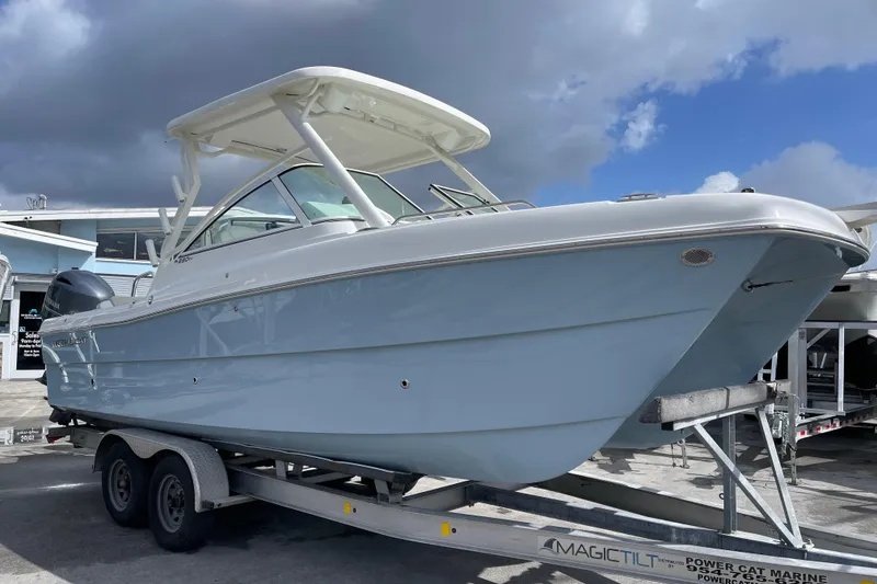 Slide: The Image of 2025 World Cat 230 DC boat on trailer under cloudy sky. - 1