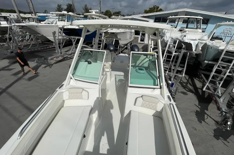 Slide: The Image of 2025 World Cat 230 DC boat in a marina, surrounded by other vessels. - 12