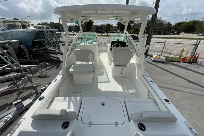 Slide: The Image of 2025 World Cat 230 DC boat interior with seating and helm, parked on a trailer. - 5
