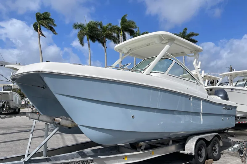 The Image of 2026 World Cat 230 DC boat displayed outdoors under a sunny sky. - 0