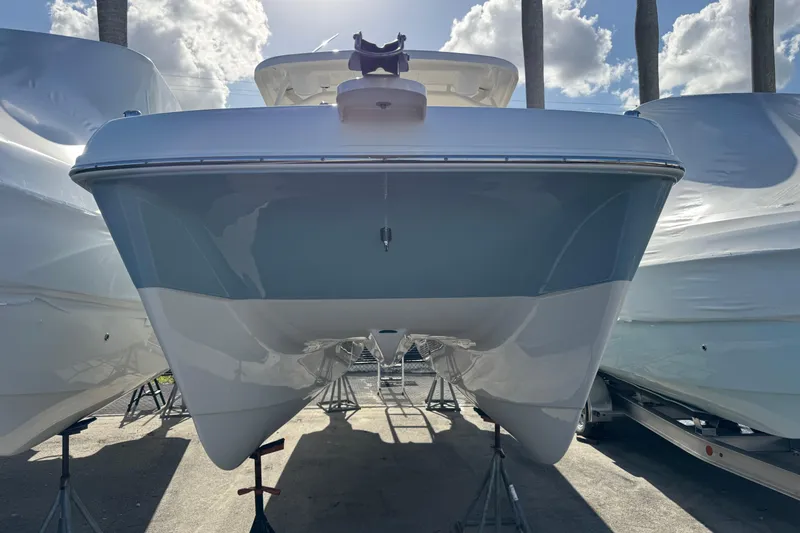 Slide: The Image of 2026 World Cat 230 DC boat on display, viewed from the front under a sunny sky. - 15