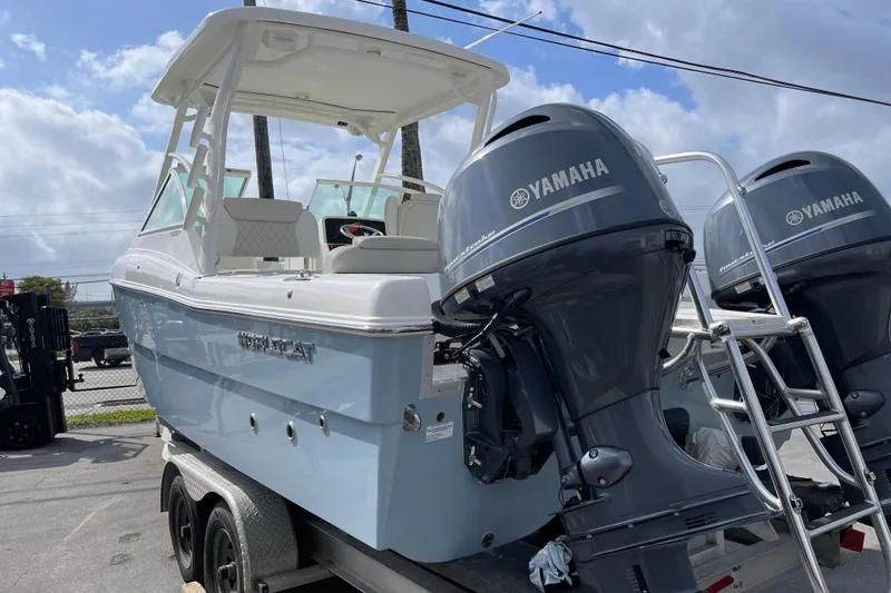 Slide: The Image of 2026 World Cat 230 DC boat with twin Yamaha 150 engines, docked under clear blue sky. - 3