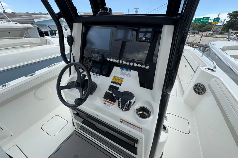 Slide: The Image of 2026 World Cat 235 TE boat console with steering wheel and navigation equipment. - 17