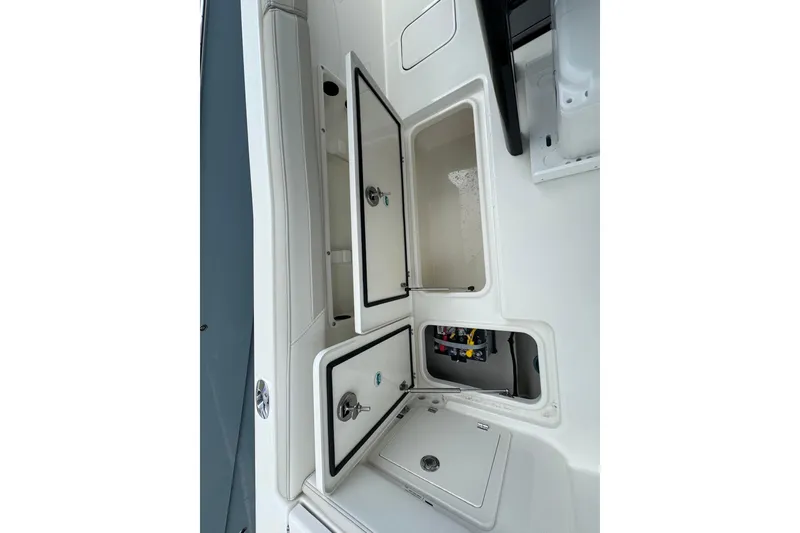 Slide: The Image of 2026 World Cat 235 TE boat interior storage compartments and seating area. - 19
