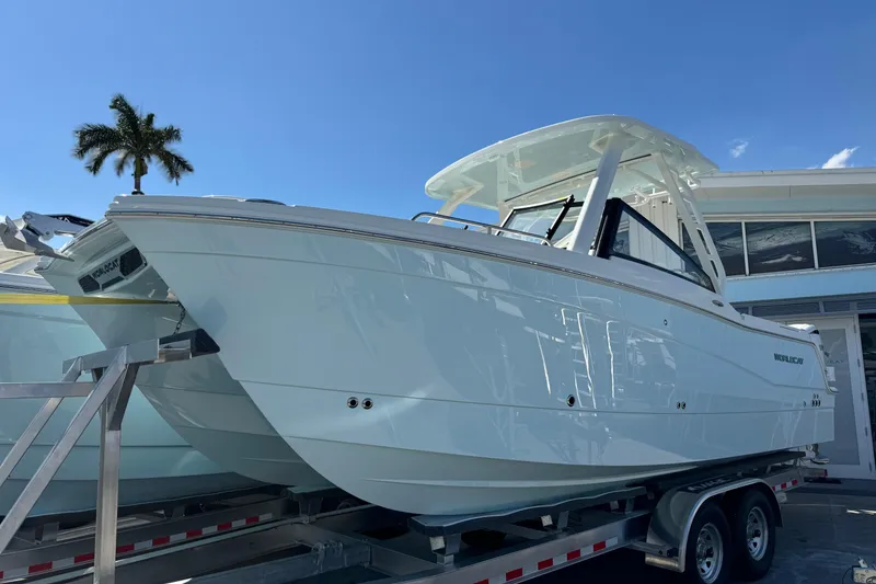 The Image of 2026 World Cat 265 DC-X boat on trailer under clear blue sky. - 0