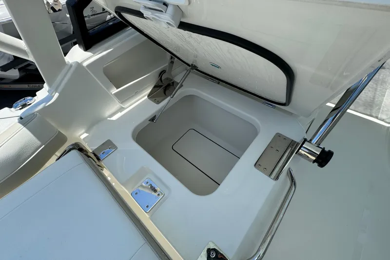 Slide: The Image of 2026 World Cat 265 DC-X boat storage compartment with open lid, showcasing interior design. - 14