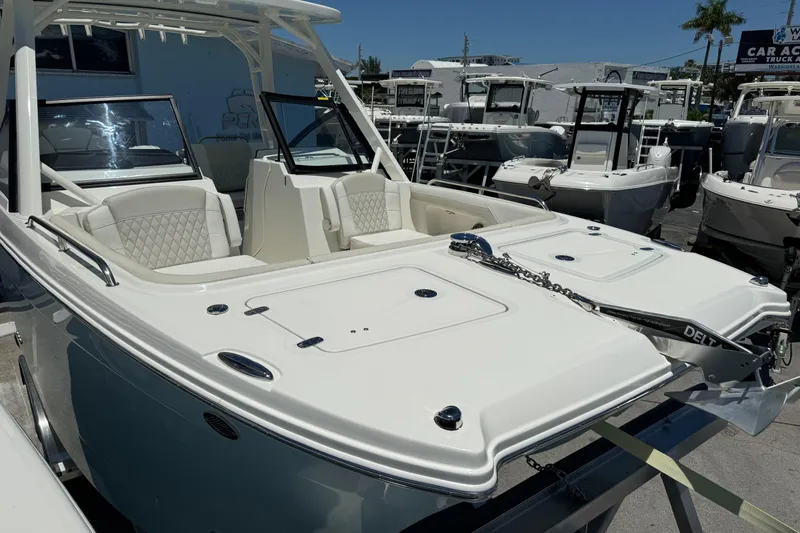 Slide: The Image of 2026 World Cat 265 DC-X boat displayed at a dealership, featuring sleek design and seating. - 27