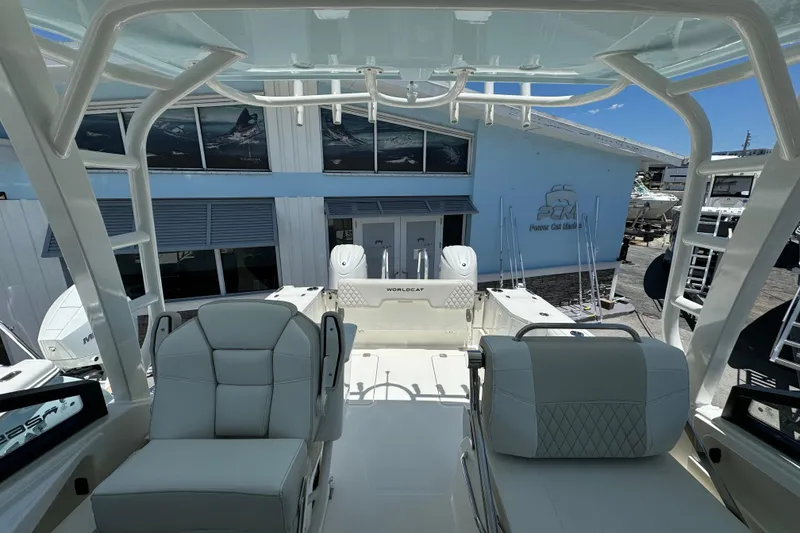 Slide: The Image of 2026 World Cat 265 DC-X boat interior with seating and helm, at a marina. - 7