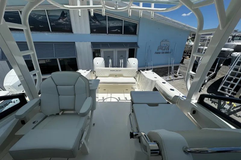 Slide: The Image of 2026 World Cat 265 DC-X boat interior with seating and helm, docked at a marina. - 9