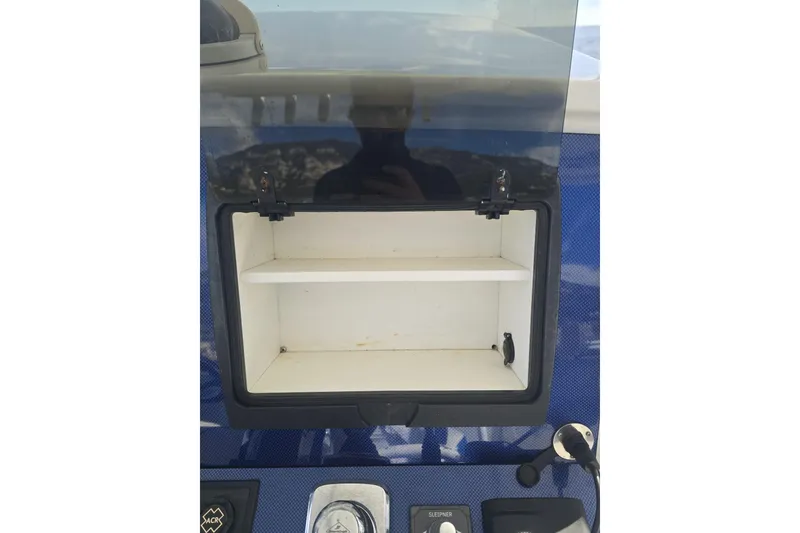 Slide: The Image of Open storage compartment on 2014 Midnight Express 37 EXK boat dashboard. - 23