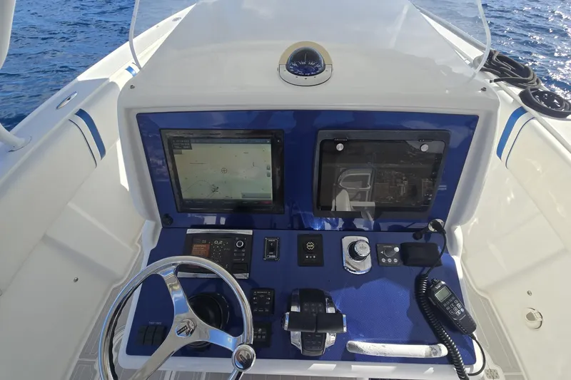 Slide: The Image of Control panel of a 2014 Midnight Express 37 EXK boat with navigation screens and steering wheel. - 30