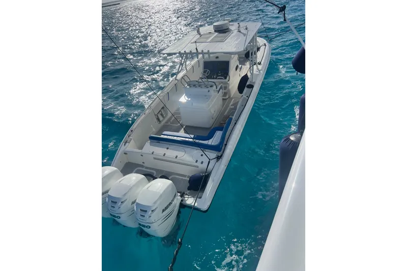 Slide: The Image of 2014 Midnight Express 37 EXK boat on clear blue water, featuring triple Mercury engines. - 4