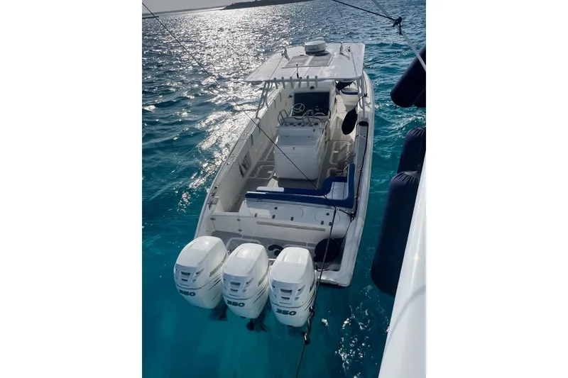 Slide: The Image of 2014 Midnight Express 37 EXK boat with triple engines on clear blue water. - 9