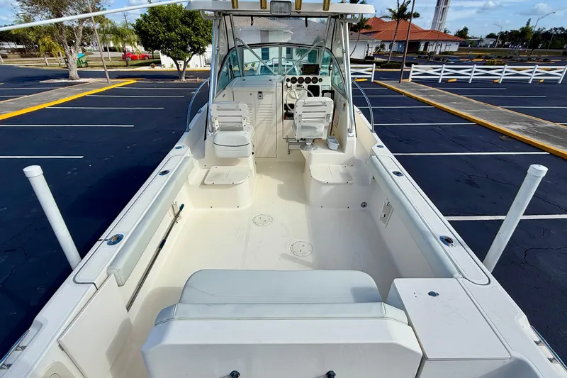 Slide: The Image of 1999 Pursuit 2470 Walkaround boat interior, featuring spacious seating and helm controls. - 12