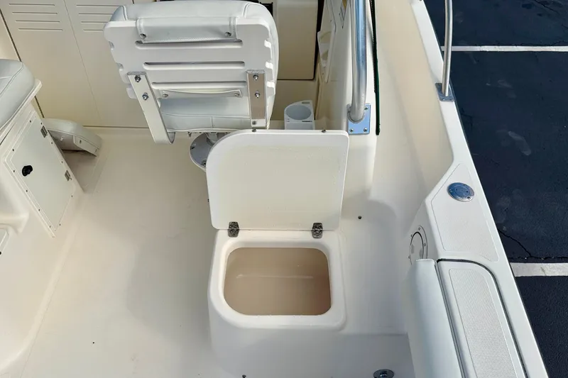 Slide: The Image of 1999 Pursuit 2470 Walkaround boat interior with open storage compartment and seating. - 15