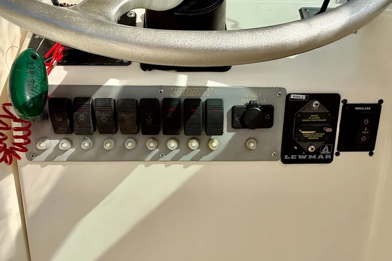 Slide: The Image of 1999 Pursuit 2470 Walkaround boat control panel with switches and Lewmar windlass. - 22