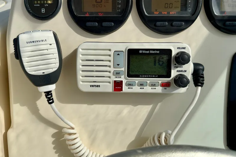 Slide: The Image of 1999 Pursuit 2470 Walkaround boat dashboard with West Marine VHF585 radio and gauges. - 23