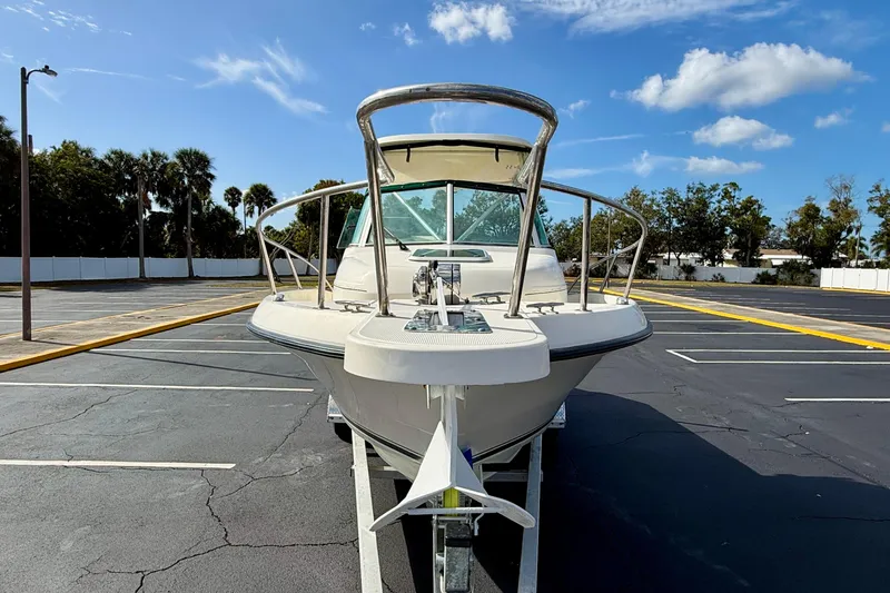 Slide: The Image of 1999 Pursuit 2470 Walkaround boat on trailer in parking lot under blue sky. - 3
