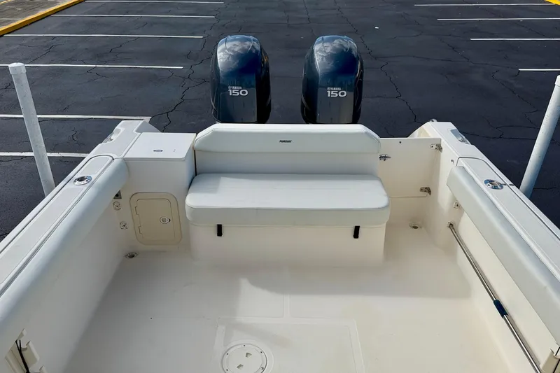 Slide: The Image of 1999 Pursuit 2470 Walkaround boat with twin Yamaha 150 engines, parked in a lot. - 31