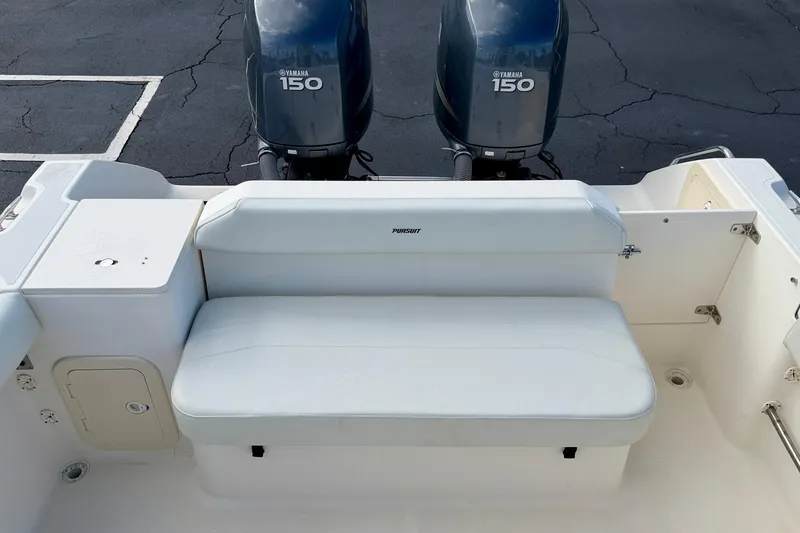 Slide: The Image of 1999 Pursuit 2470 Walkaround boat with Yamaha 150 engines, featuring a white cushioned bench seat. - 32