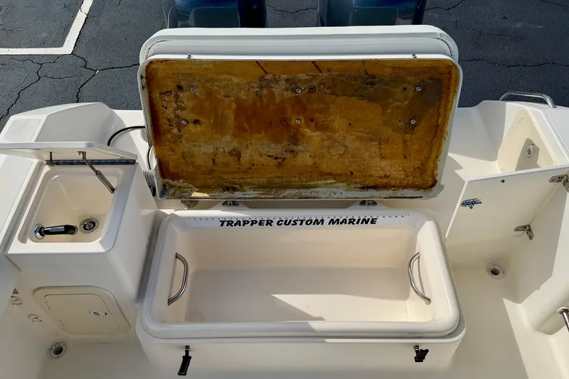 Slide: The Image of 1999 Pursuit 2470 Walkaround boat with open storage compartment and sink. - 33