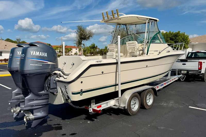 Slide: The Image of 1999 Pursuit 2470 Walkaround boat on trailer with twin Yamaha engines. - 5