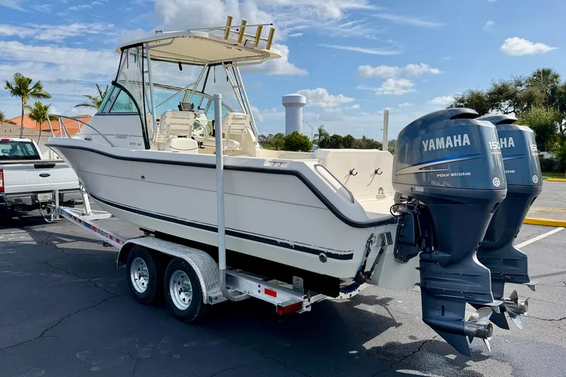 Slide: The Image of 1999 Pursuit 2470 Walkaround boat with dual Yamaha engines on a trailer. - 7