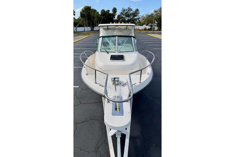 Slide: The Image of 1999 Pursuit 2470 Walkaround boat on trailer in parking lot. - 9