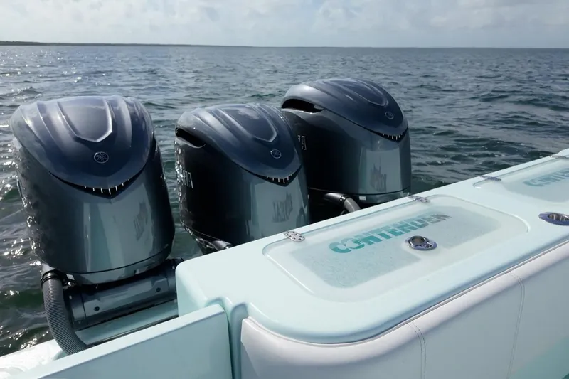 Slide: The Image of 2025 Contender 39 ST boat with triple outboard engines on open water. - 9