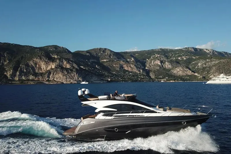 Slide: The Image of Luxurious 2025 Cobrey 52 FLY yacht cruising near scenic coastal cliffs. - 3