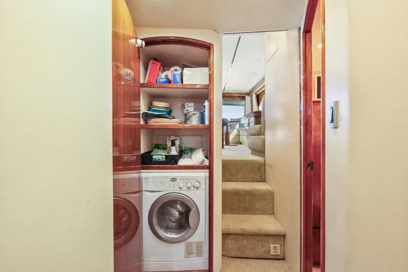 Slide: The Image of Laundry area inside 2013 Viking 46 Convertible yacht, featuring washer and storage shelves. - 32