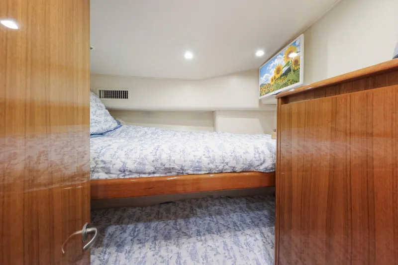 Slide: The Image of Cozy bedroom in 2013 Viking 46 Convertible yacht with wooden cabinetry and floral bedding. - 34
