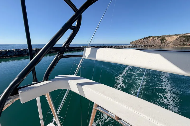 Slide: The Image of 2013 Viking 46 Convertible yacht navigating coastal waters with scenic cliff view. - 38