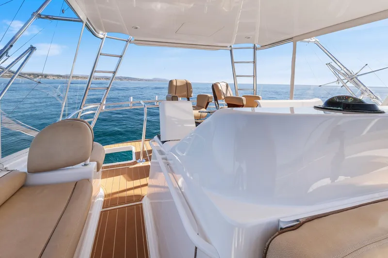 Slide: The Image of 2013 Viking 46 Convertible yacht interior with beige seating, ocean view, and clear skies. - 57