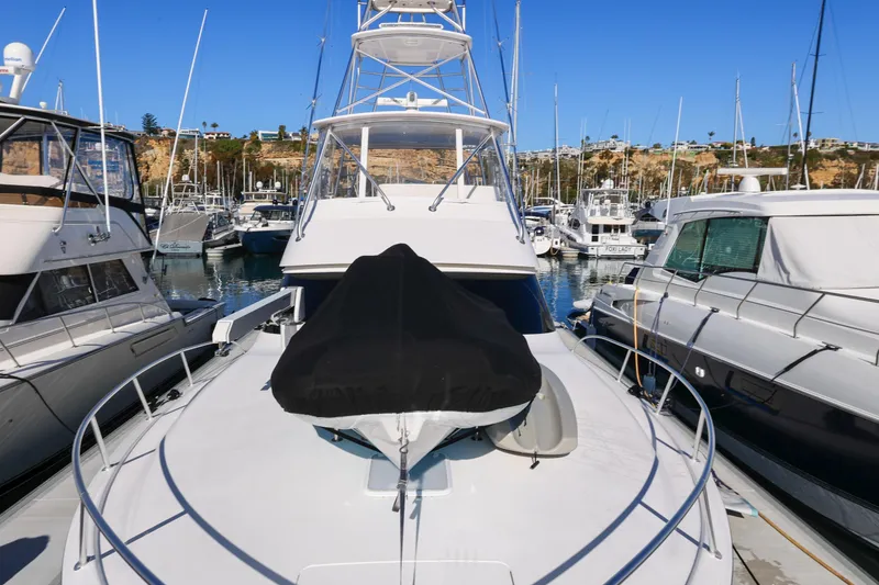 Slide: The Image of 2013 Viking 46 Convertible yacht docked in a marina, surrounded by other boats. - 67