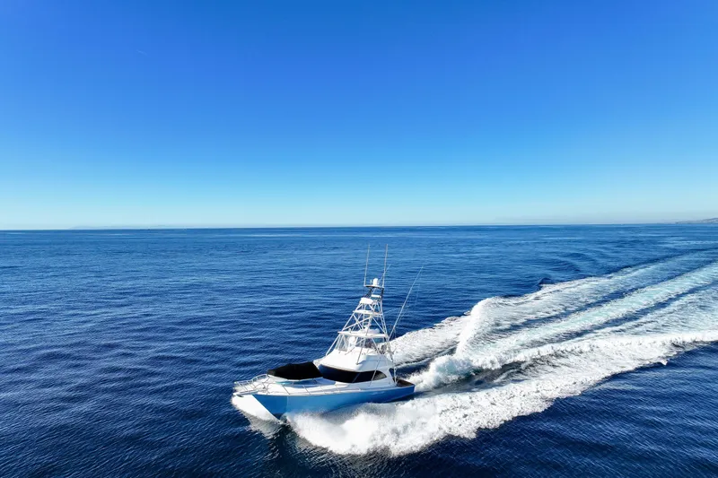 Slide: The Image of 2013 Viking 46 Convertible yacht cruising on open blue ocean under clear sky. - 72
