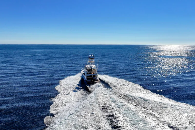 Slide: The Image of 2013 Viking 46 Convertible yacht cruising on open ocean under clear blue sky. - 73