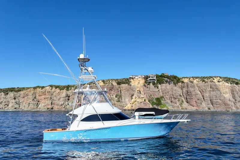 Slide: The Image of 2013 Viking 46 Convertible yacht on blue ocean near rocky cliffs. - 79