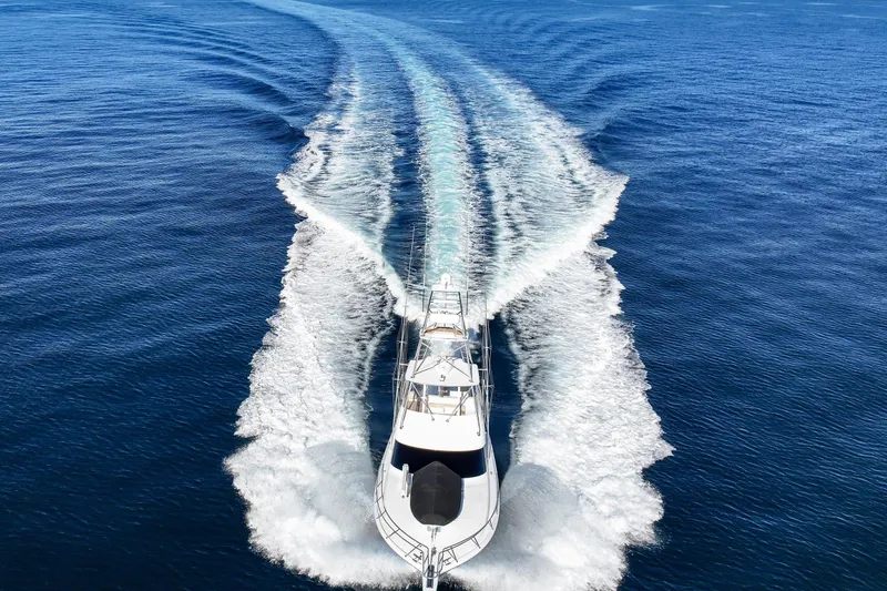 Slide: The Image of 2013 Viking 46 Convertible yacht cruising on open blue water, leaving a wake. - 82