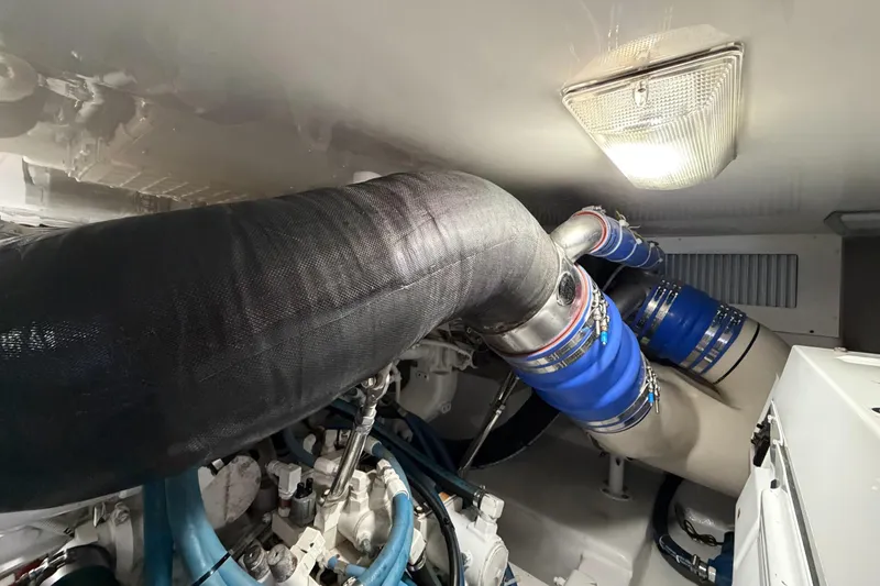 Slide: The Image of Engine room of 2013 Viking 46 Convertible yacht with blue hoses and exhaust system. - 89