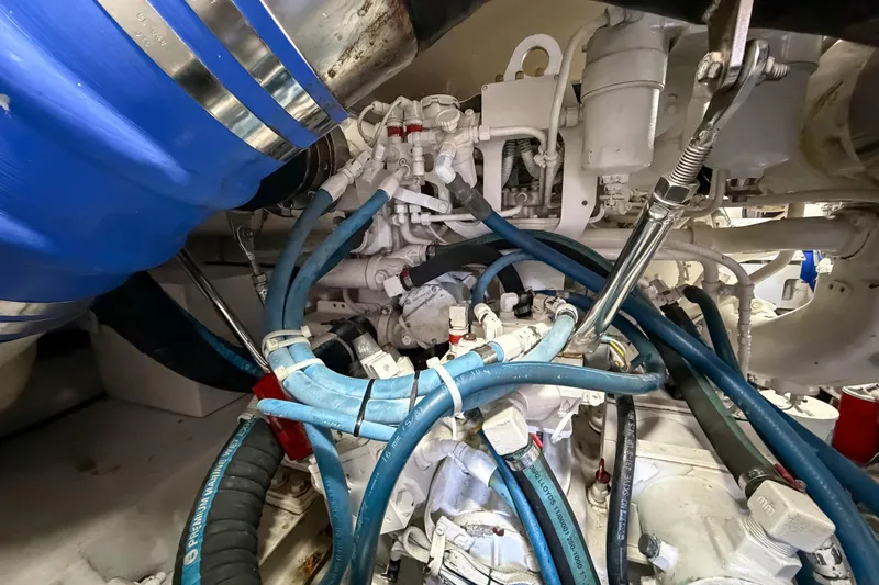 Slide: The Image of Engine room of 2013 Viking 46 Convertible with blue hoses and mechanical components. - 91