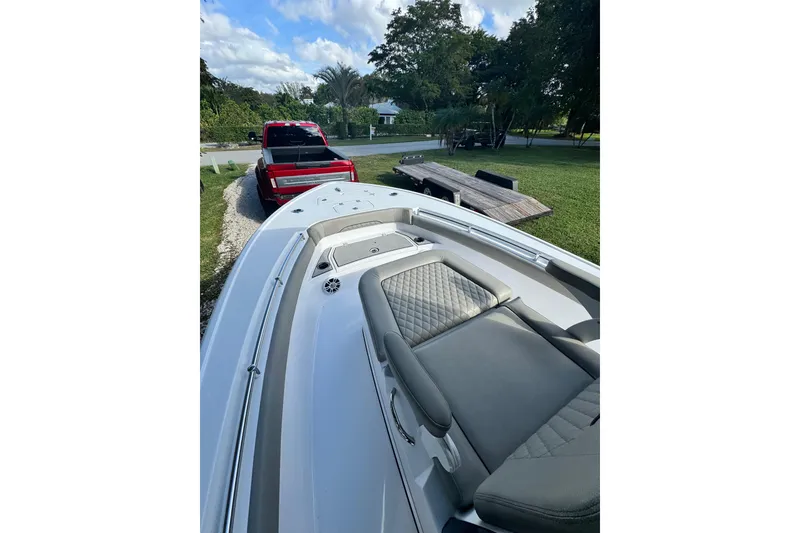 Slide: The Image of 2024 Sportsman Masters 247OE Bay Boat with sleek design, parked near a red truck. - 12