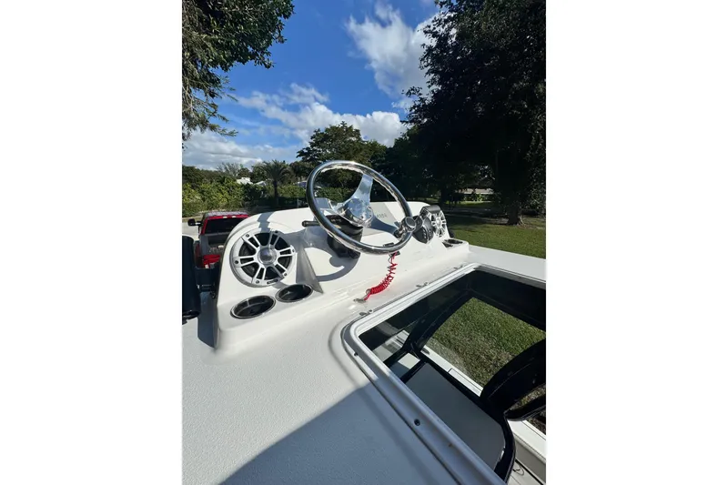 Slide: The Image of 2024 Sportsman Masters 247OE Bay Boat dashboard with steering wheel and speakers. - 24