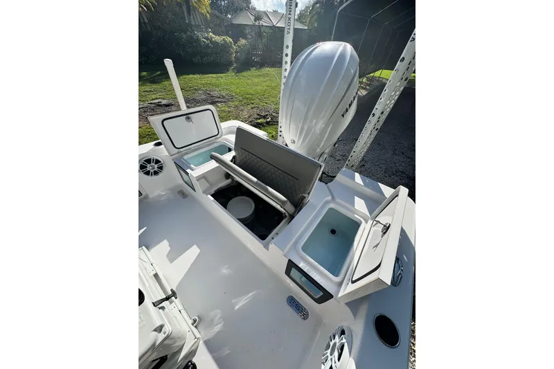 Slide: The Image of 2024 Sportsman Masters 247OE Bay Boat interior with open storage compartments and engine view. - 25