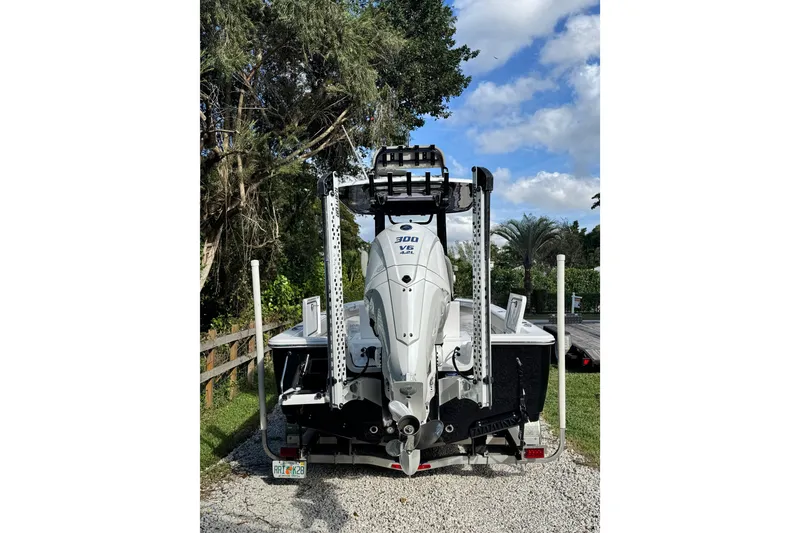 Slide: The Image of 2024 Sportsman Masters 247OE Bay Boat with powerful outboard motor, parked outdoors. - 3