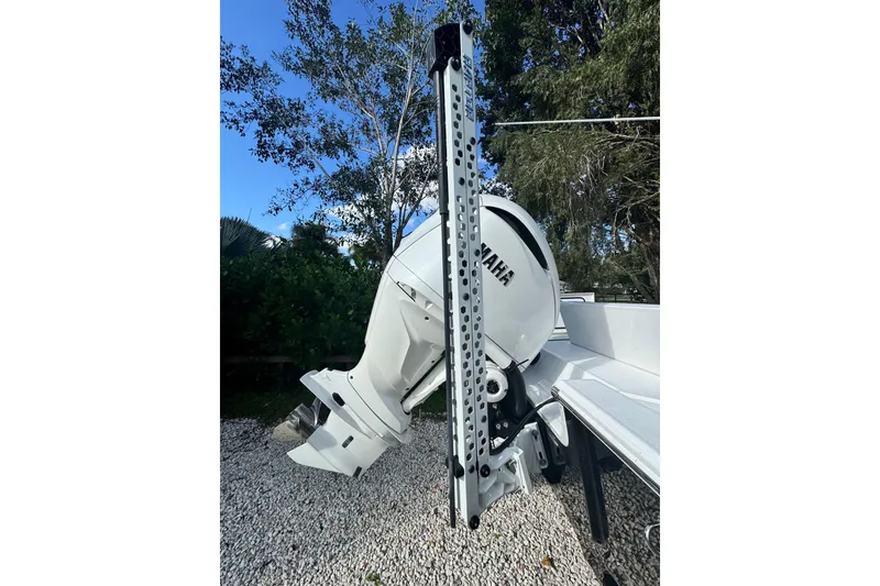 Slide: The Image of 2024 Sportsman Masters 247OE Bay Boat with Yamaha outboard engine, parked on gravel. - 4