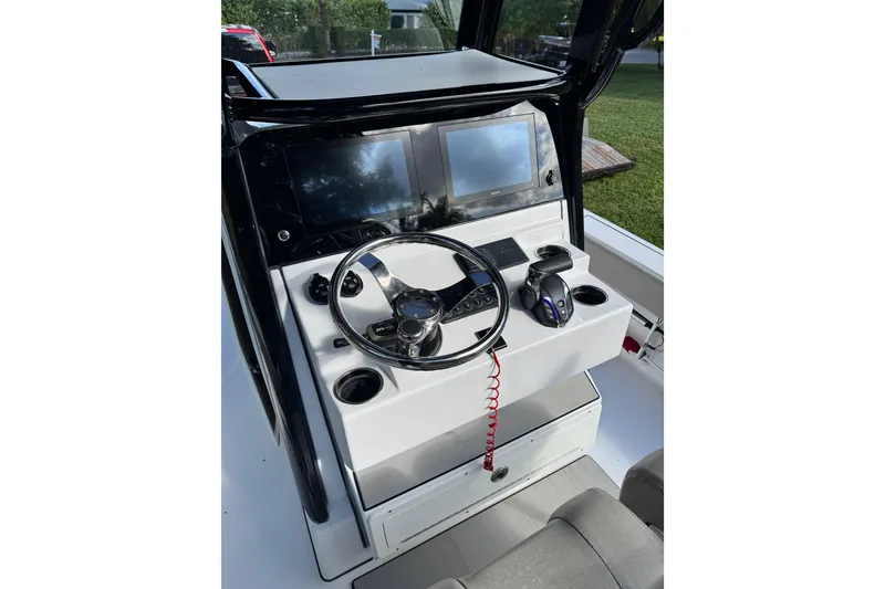 Slide: The Image of 2024 Sportsman Masters 247OE Bay Boat console with steering wheel and dual screens. - 5