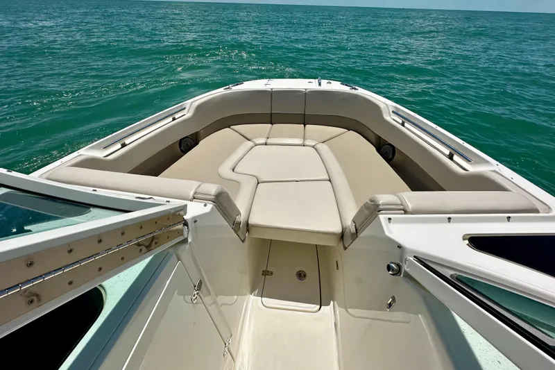 Slide: The Image of 2018 Boston Whaler 320 Vantage boat interior with cushioned seating, on open water. - 12
