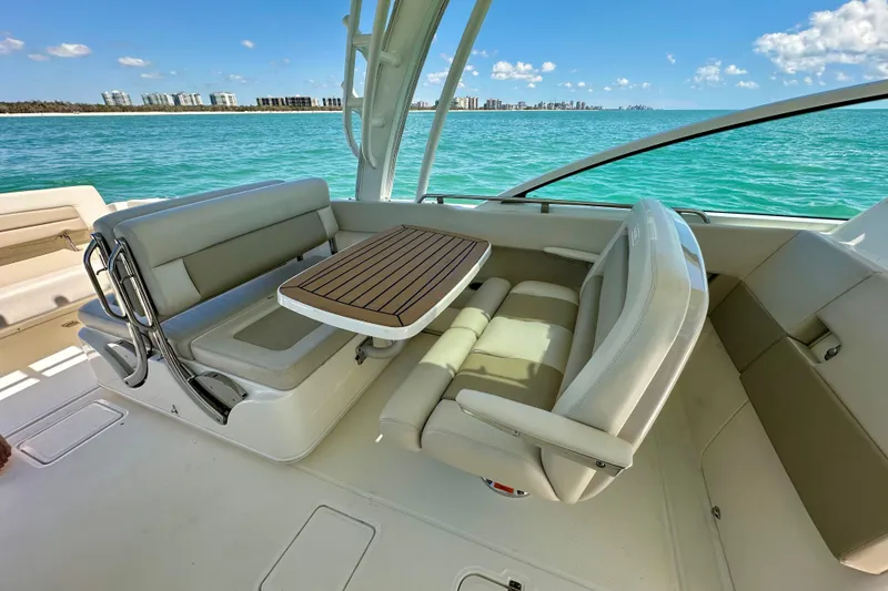 Slide: The Image of 2018 Boston Whaler 320 Vantage interior with seating and table, overlooking ocean view. - 16
