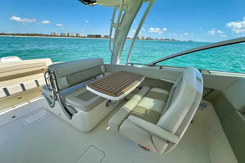 Slide: The Image of 2018 Boston Whaler 320 Vantage boat interior with seating and table, ocean view. - 17